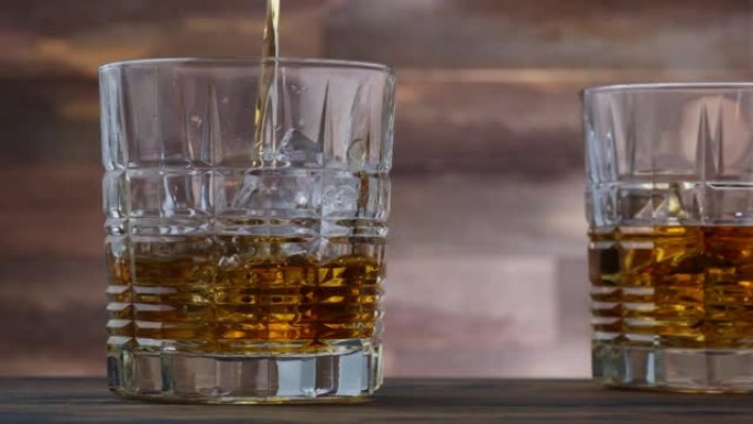 倒入玻璃中的金色威士忌或苏格兰威士忌。在木桌上两杯酒精