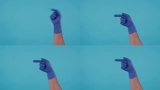 蓝色外科乳胶手套指向左侧的男性手孤立在蓝色背景上