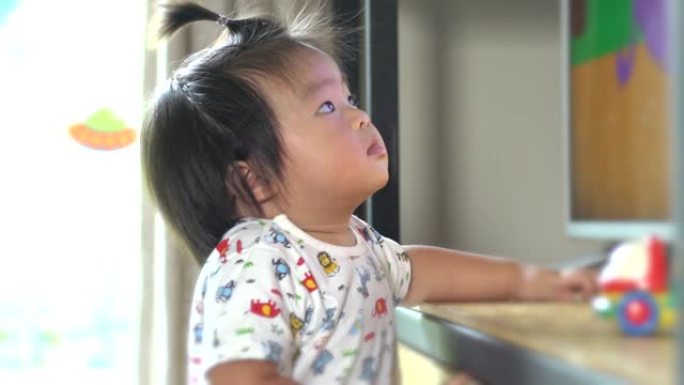 亚洲宝宝在家看动画片。