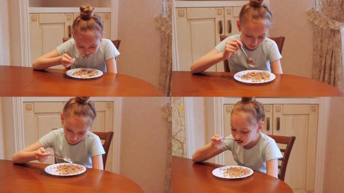 十几岁的女孩在家庭厨房吃荞麦粥。年轻女孩在厨房餐桌上吃荞麦。饮食营养和健康食品。