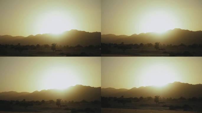 埃及沙漠山脉的壮丽景色。地平线下太阳的灯光照亮了山脉上方的天空轮廓，4k