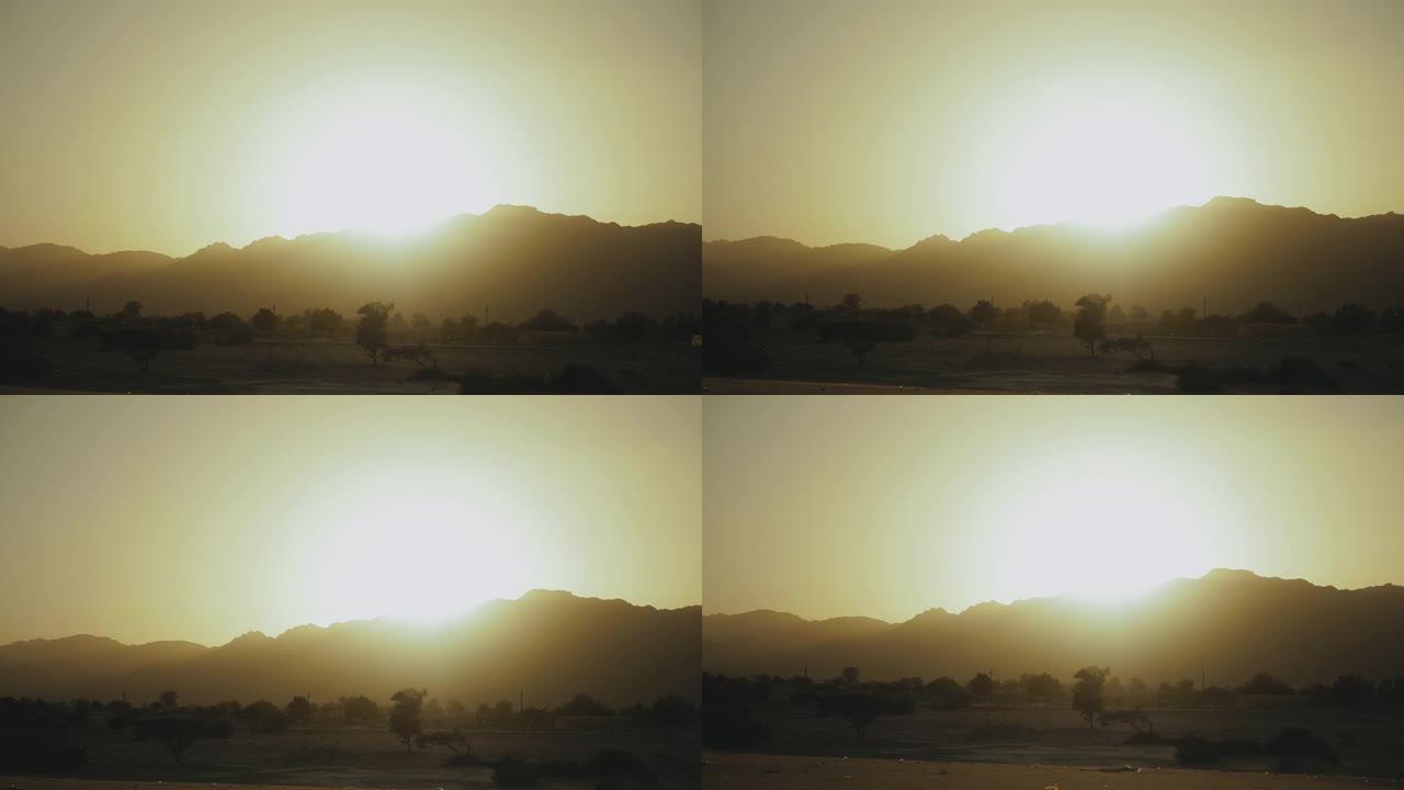 埃及沙漠山脉的壮丽景色。地平线下太阳的灯光照亮了山脉上方的天空轮廓，4k