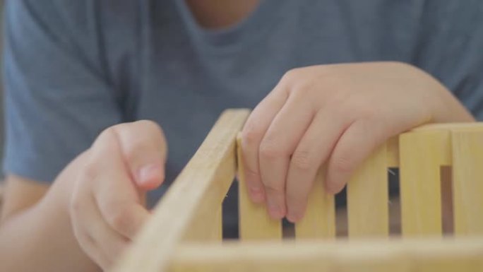 亚洲男孩拆箱木架，在家自制钻孔。