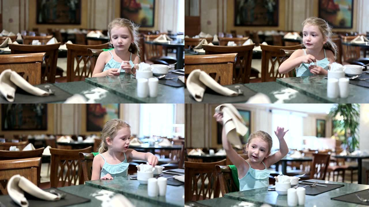 小女孩坐在一个大餐厅大厅里。