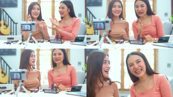 快乐微笑的两个年轻的亚洲女人或美容博主在录制视频和挥手的同时交谈和看着相机，在家工作的概念。美女视频