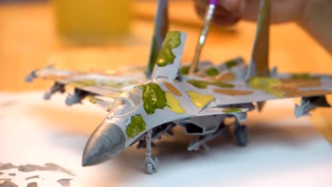 刷子漆一架塑料军用飞机的机身