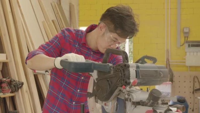 工人青年亚洲男子木匠建筑设计和切割木制锯床在车间办公工作室工作，个人经营理念。