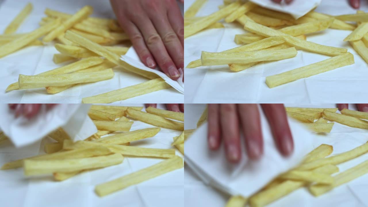 用纸巾/餐巾近距离烘干新鲜炸薯条。