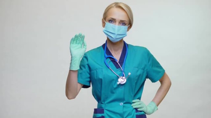 带听诊器和防护面罩的医生护士妇女-挥舞着相机手势