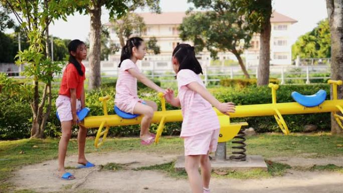 快乐的亚洲女孩一起在操场上玩海景。