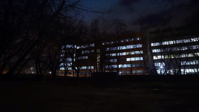 晚上的办公楼。一座办公楼的外部，傍晚时分有带灯的窗户。