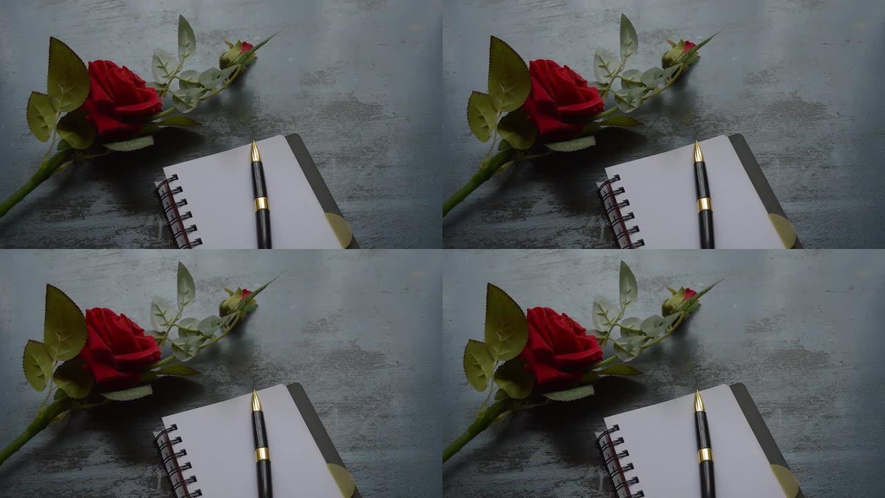 空白页笔记本、钢笔和乡村金属地板背景上的美丽红玫瑰，带有复制空间。情人节婚礼和假期的情书写作建议或建