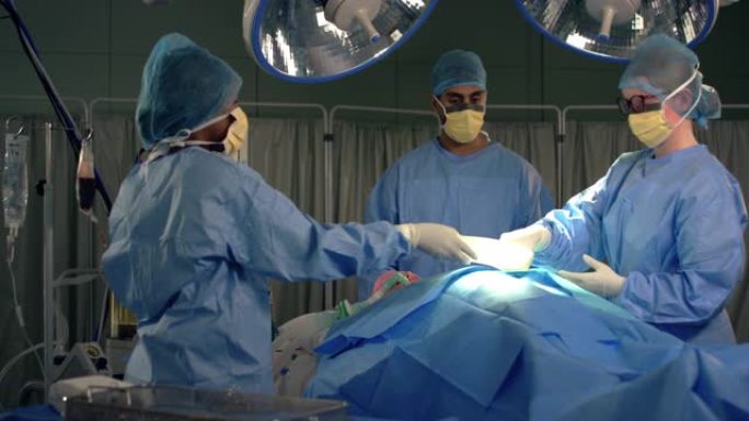 女助理将手术器械传递给外科医生