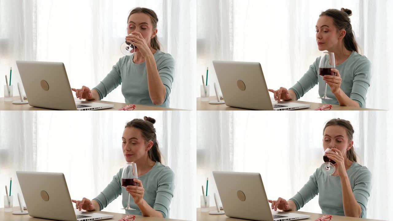用一杯酒在笔记本电脑上工作的女人