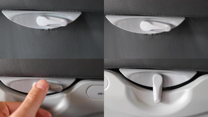 飞机托盘工作台锁。乘客手开闭飞机座椅托盘台特写