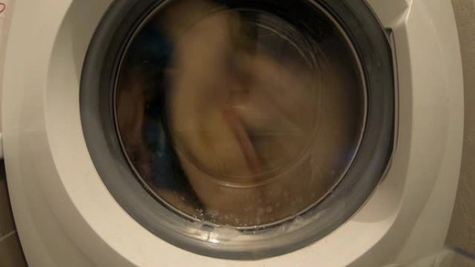 衣服在洗衣机里旋转。洗涤过程。延时。