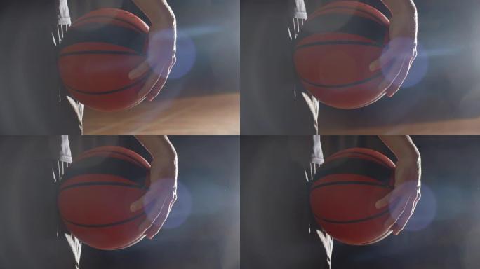 篮球运动员手持球的特写明亮光影剪影耀斑射线