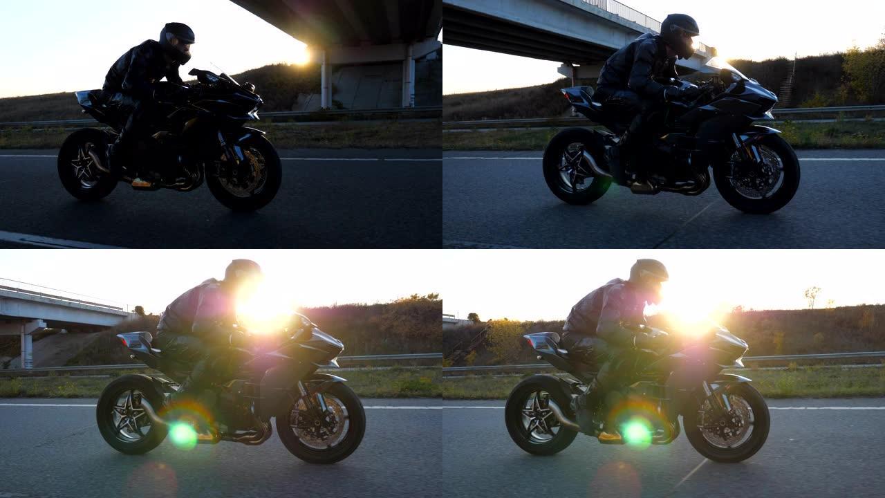 男子在高速公路上骑着现代运动摩托车，背景是太阳耀斑。摩托车手在乡间小路上骑摩托车。旅途中开车的人。自