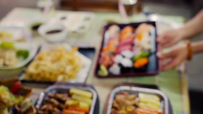 一群人在拍摄寿司、牛排、萨尔曼、天妇罗一种日本食物。