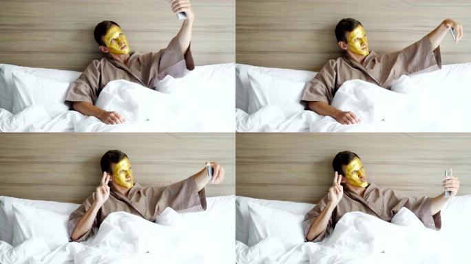 戴着金色面罩的家伙在酒店的柔软床上自拍