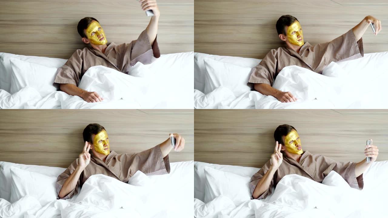戴着金色面罩的家伙在酒店的柔软床上自拍