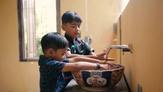 孩子们兄弟正在浴室洗手。印尼或马拉西亚兄弟姐妹一起洗手