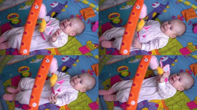 在卧室玩玩具的女婴。幸福家庭理念。漂亮的宝宝在室内玩玩具。