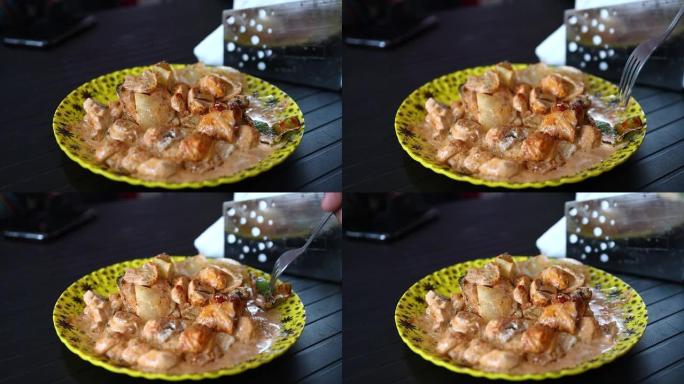 用盘子里的叉子吃鸡肉雷扎拉。
