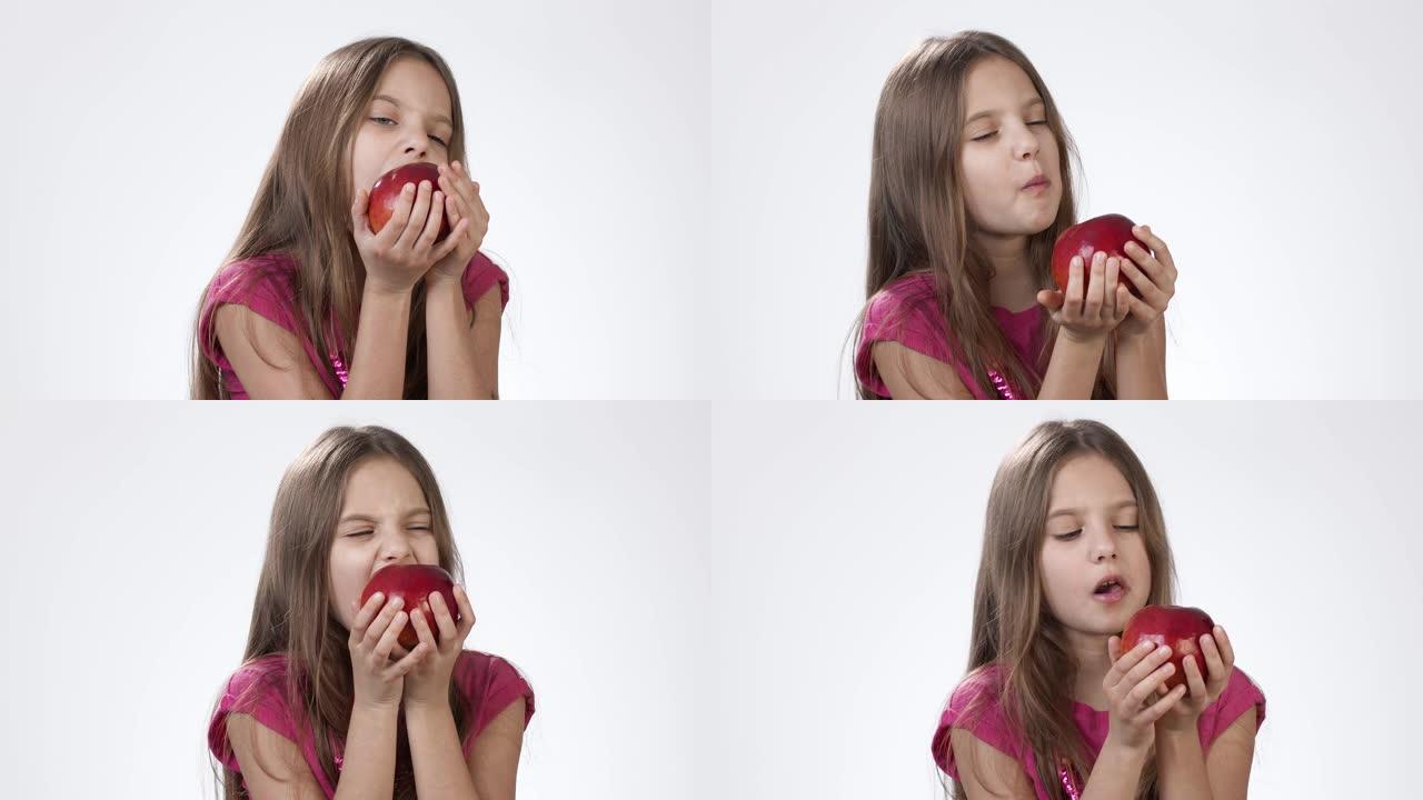白色小女孩吃一个大红苹果。一个女孩咬了一块红灰，尝了尝。