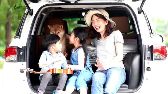 一个亚洲家庭和一只柴犬一起玩。家庭有母子，女儿在汽车公路旅行。