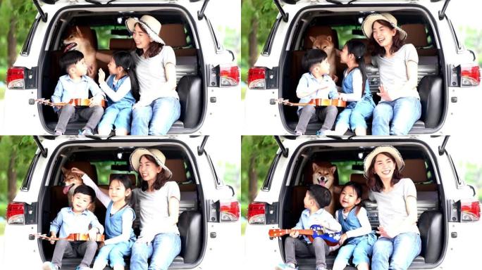 一个亚洲家庭和一只柴犬一起玩。家庭有母子，女儿在汽车公路旅行。