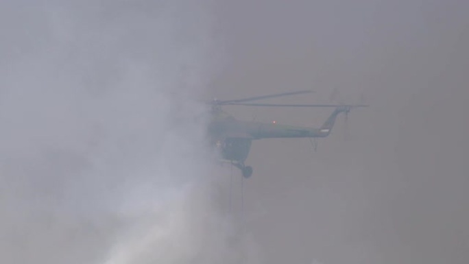 空降部队在浓烟中从一架军用直升机的后挡板中降落