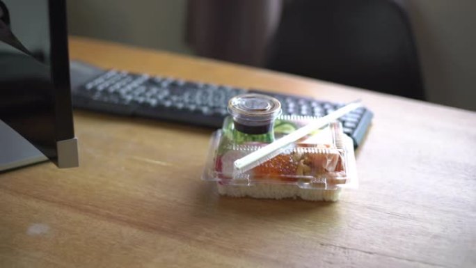 办公桌上塑料容器中的日本食物