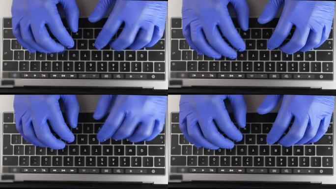 医生的手戴着蓝色手术手套在笔记本电脑键盘上打字