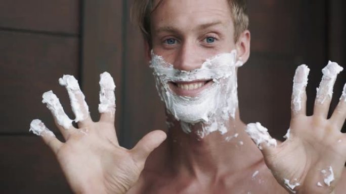一幅男子肖像把剃须泡沫抹在脸上。