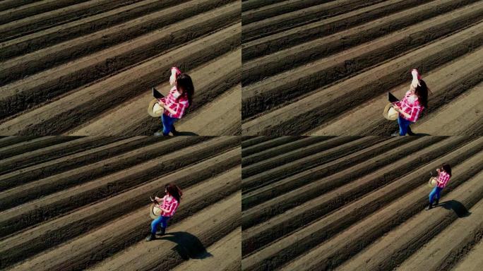 航空。女农民、农学家以特殊的土壤行在田间。她用药片测试拖拉机自动种植土豆的质量。现代农业,农业。春天