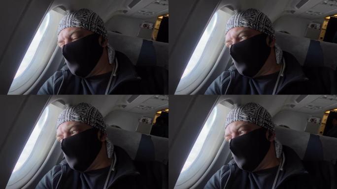 戴着医用口罩的乘客看着飞机窗外新型冠状病毒肺炎空中旅行