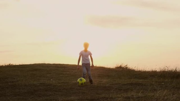 男孩在追足球。户外娱乐。天空和地平线。