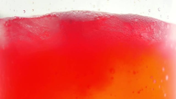 红色软饮料在玻璃杯中的气泡。