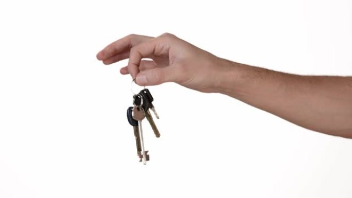 隔离的白色背景上的男人的手拿着公寓或汽车的钥匙。插入文本或背景的地方。白色背景上一个人的手的情绪。