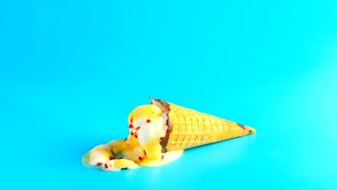 菠萝和樱桃口味的冰淇淋蛋筒掉落并融化在蓝色背景上时光倒流