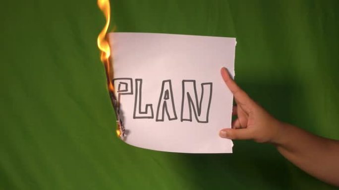 一只手握着燃烧的纸，上面写着计划文字。