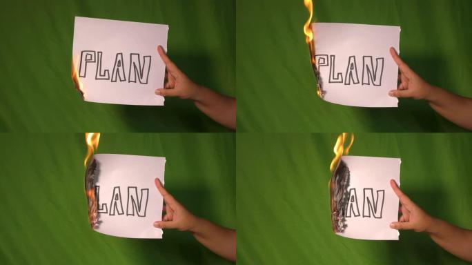 一只手握着燃烧的纸，上面写着计划文字。