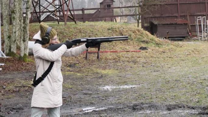 女孩用猎枪向射击场的目标射击。墨盒外壳12口径