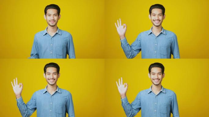 年轻的亚洲男子微笑着展示他的好兆头，快乐的亚洲男子看着相机，同时在工作室里站在黄色背景上展示好的手势