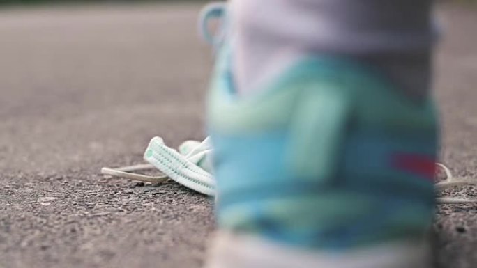 一个穿着运动鞋的女人踩着躺在路上的医用口罩。大流行的结束。