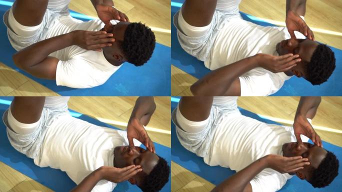 年轻的非洲裔美国男子在健身房的瑜伽垫上做仰卧起坐运动