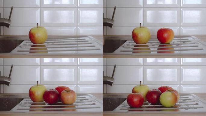男人的近景在厨房的水槽里洗成熟的苹果。