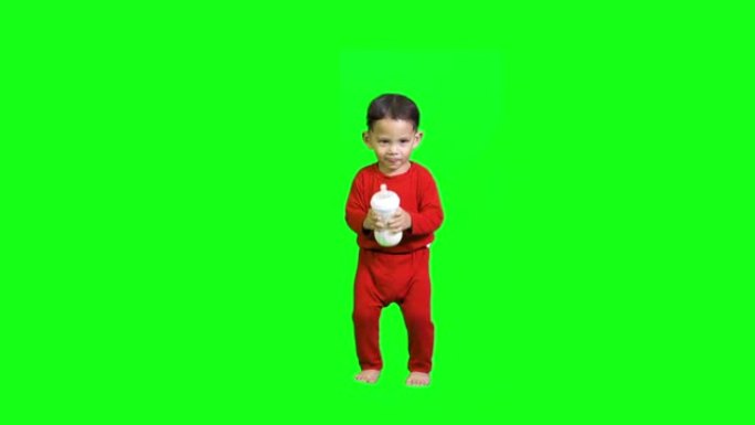 可爱的小孩亚洲人在玩耍，跳舞，跳跃和散步。快乐的一岁男孩。在绿色屏幕上做鬼脸和微笑。
