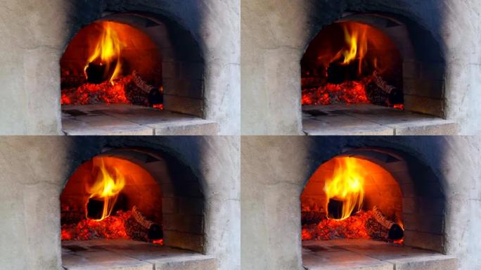 火在披萨烤箱中燃烧，在火烧的热木头在烤箱中烘烤